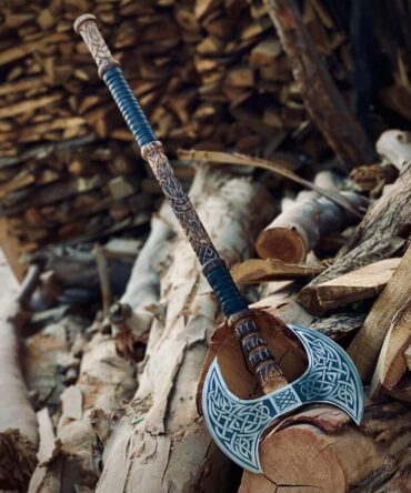 Viking Double Headed Axe with engraved Celtic knotwork and a hand-carved handle, resting on a pile of firewood.